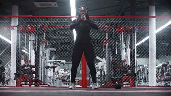 An Africanamerican Sportive Woman Squatting in a Gym