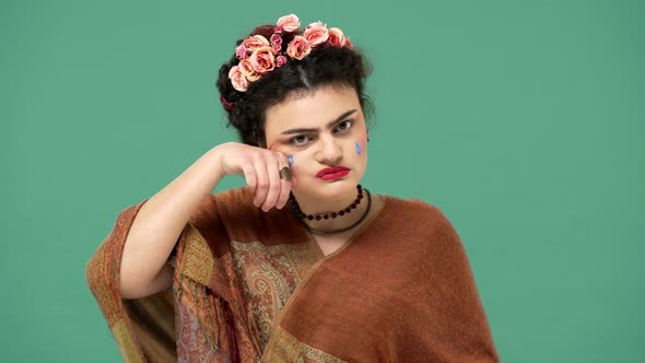 Portrait of Woman Style Icon and Famous Celebrity Frida Kahlo Posing with Painting on Her Face and