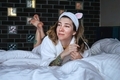 A young woman in a funny headband with ears lies on the bed and relax - PhotoDune Item for Sale