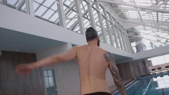 Swimmer in Trunks and Cap Warming Up