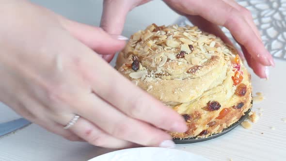 A Woman Cuts A Cooked Cruffin With Raisins And Candied Fruits With A Knife. Close Up.