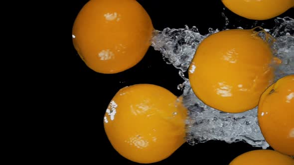 Group of Delicious Oranges are Flying Horizontally with Water Splashes