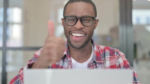 Close Up of African Man with Laptop Showing Thumbs Up