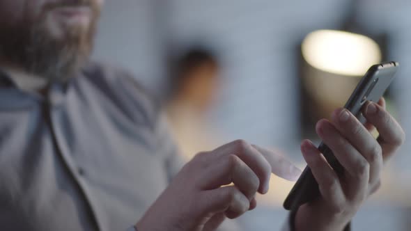 Man with Beard Typing on Mobile Phone