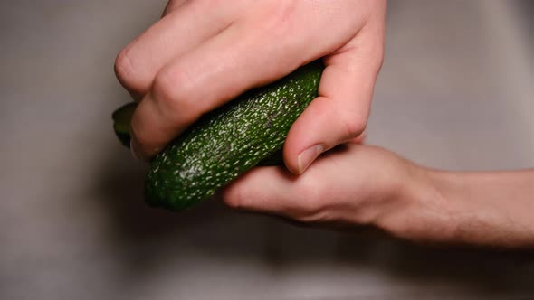 male hands open avocado in half. Fresh ripe avocado, Healthy breakfast, Vegetarian food