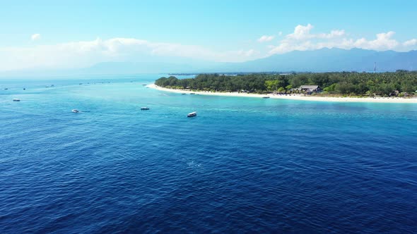 Tropical aerial tourism shot of a paradise sunny white sand beach and blue water background