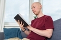 Bald man reading book on couch - PhotoDune Item for Sale