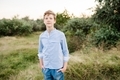 Portrait of blond teenager boy standing in field in nature - PhotoDune Item for Sale
