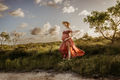 A pregnant woman wearing a hat and a pink dress in the countryside  - PhotoDune Item for Sale