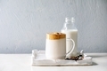 Dalgona frothy coffee trend Korean drink milk latte with coffee foam in glass mug on ceramic tray - PhotoDune Item for Sale