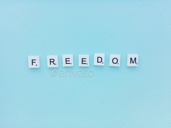 Freedom scrabble letters word on a blue background 