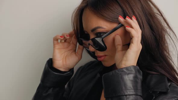 Female Fashion Model in Black Taking Off Stylish Sunglasses