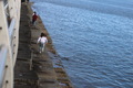Young people running on a stairs on breakwater by the ocean  - PhotoDune Item for Sale