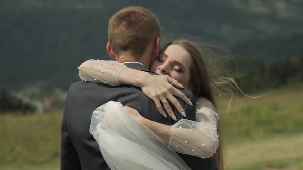 Groom with Bride Having Fun on a Mountain Hills. Wedding Couple Hugging