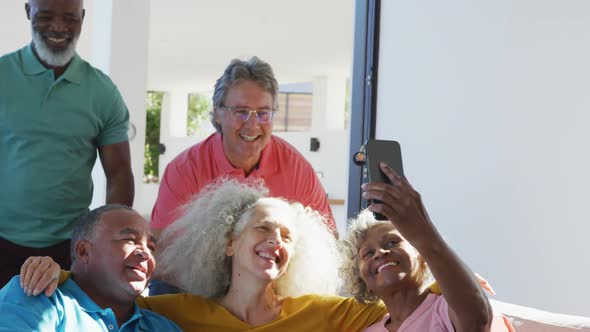 Happy senior diverse people taking selfie at retirement home