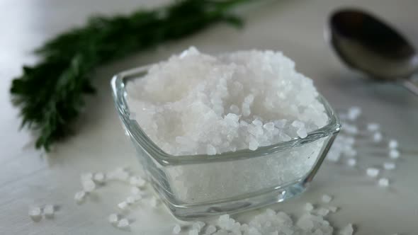 Chef with Fingers Take a Pinch of Coarse Sea Salt From the Salt Shaker on the Kitchen Table