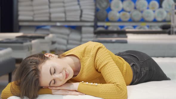 Stunning Woman Smiling to the Camera While Lying on Orthopedic Mattress