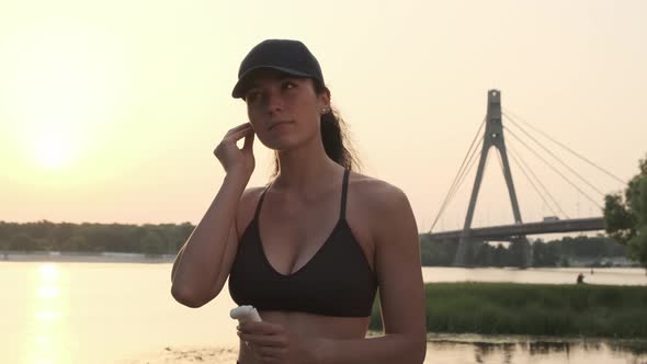 Young Fit Woman Using Her Earphones Before Run