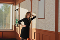 portrait of a woman wearing black dress standing near the wall in billiards club. - PhotoDune Item for Sale
