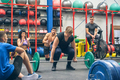 Woman ready to do lifting weights while her gym mates cheering her on - PhotoDune Item for Sale