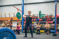 Proud woman weightlifting while her gym mates cheering her on - PhotoDune Item for Sale