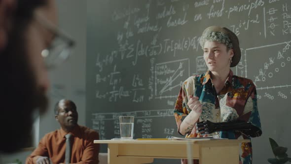 Female Student with Prosthetic Arm Talking on Lesson