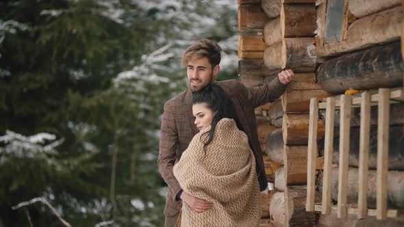 Couple Near a Wooden House