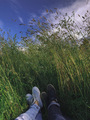 A couple in sneakers are lying in the grass. - PhotoDune Item for Sale