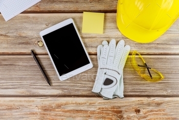  safety equipment on gloves yellow helmet and digital tablet pc