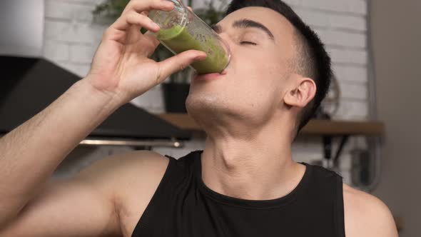 Making Green Juice at Home Young Sporty Man in Sportswear Drinking Smoothie From a Glass