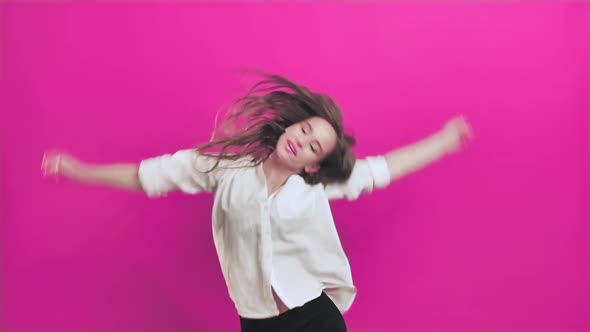 Young Woman Having Fun Smiling Dancing in Studio Shaking Hair While Listening to Music 