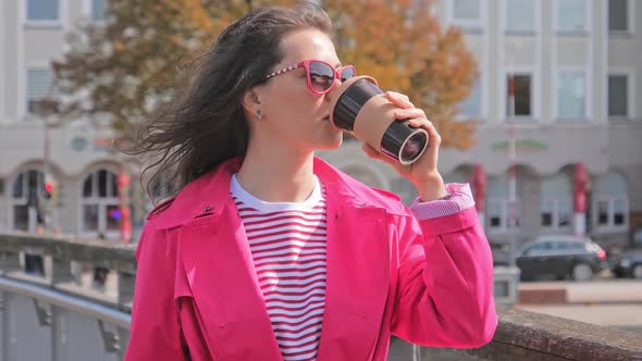 Woman Drinking Coffee on Bridge and Enjoying City View