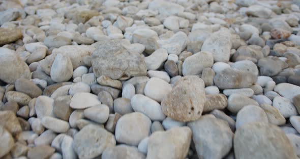 flight from steadicam over many stones on the beach near the sea