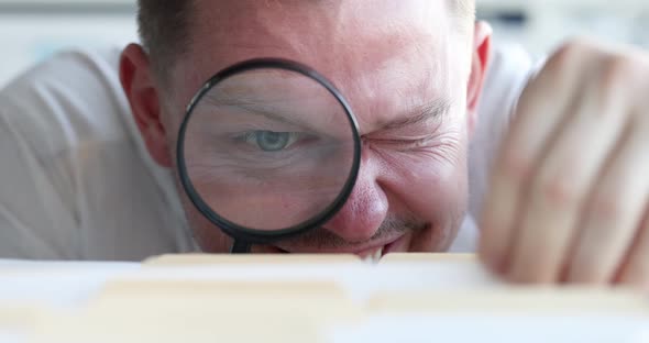 Young Man Looks Through Magnifying Glass at Document Slow Motion  Movie