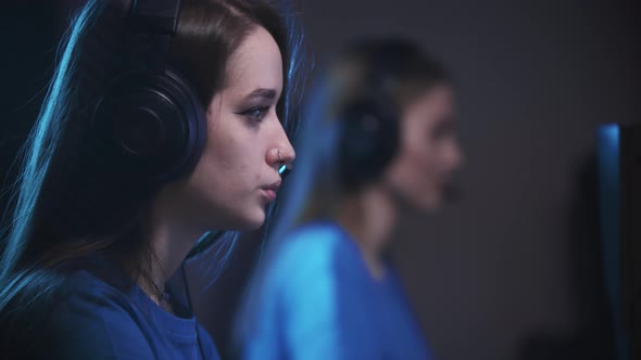 Friends Playing an Online Game in the Gaming Club  a Woman Vaping on the Foreground