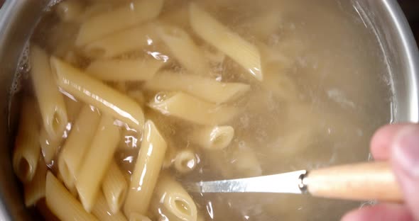 Penne Pasta Boiling in a Pot of Water. Macro Background. Top View.