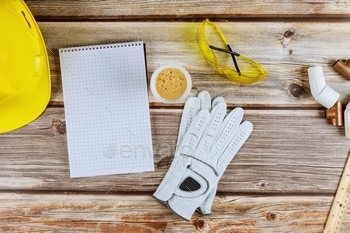 safety equipment glasses gloves helmet with notebook, cup of coffee