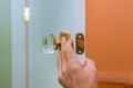 Builder in installing a door lock the door of a new house hand close-up. - PhotoDune Item for Sale