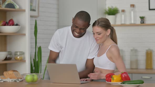 Athletic Woman and African Man Doing Video Call on Laptop in Kitchen