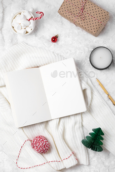 Notebook with white pages for writing down Christmas to-do lists, holiday attributes around
