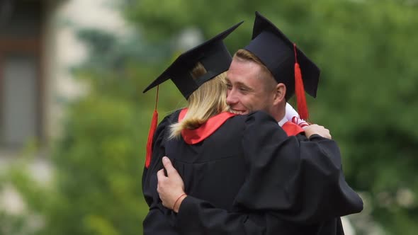 Happy Couple Graduating From University, Cheerful Man Spinning Pretty Girlfriend