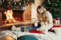 Mother and daughter hugging and warming up on a winter evening by the fireplace for Christmas - PhotoDune Item for Sale