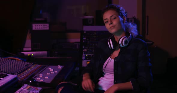 Female sound engineer sitting at a mixing desk