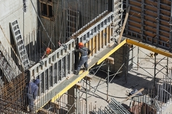 fitting assembly and marking. builders in orange helmets are building a monolithic structure 
