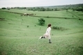 Young girl running on the green hills on the farm in the summer. - PhotoDune Item for Sale