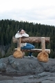 A young man in a raincoat is sitting on a bench made of wood  - PhotoDune Item for Sale