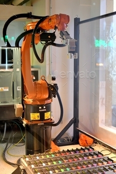 A robot arm getting ready to pick up color-coded vials in a science lab.