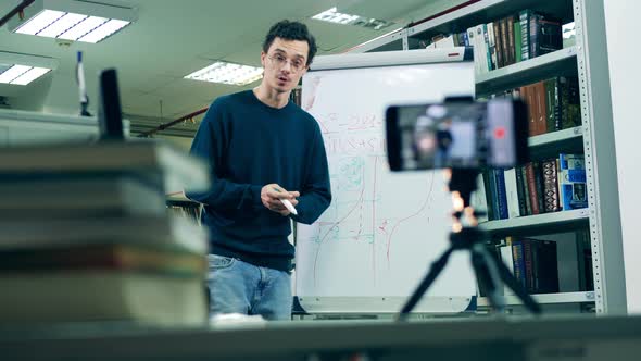 A Man Is Teaching an Online Lesson While Being in a Library