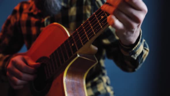 Man Play Acoustic Guitar at Blue Wall