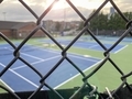 Empty tennis courts viewed through chain link fence - PhotoDune Item for Sale